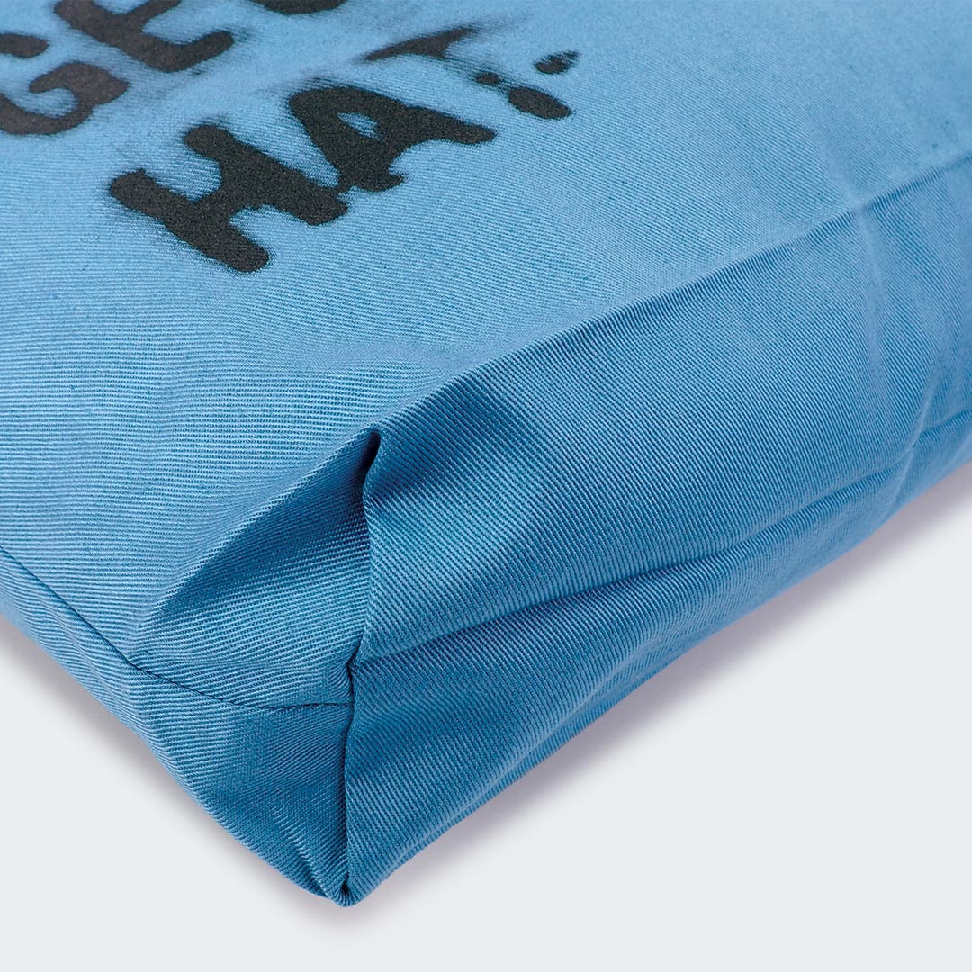 Das Bild zeigt als Detail den Boden der hellblauen Stofftasche. Der Boden ist verstärkt und verbreitert und bietet der Tasche dadurch ein höheres Volumen.