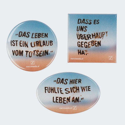 Abgebildet sind drei Kühlschrankmagnete in unterschiedlichen Formen mit Zitaten auf einem sanften Farbverlauf im Sonnenuntergangsdesign.
Runder Magnet: „Das Leben ist ein Urlaub vom Totsein.“
Eckiger Magnet: „Dass es uns überhaupt gegeben hat.“
Ovaler Magnet: „Das hier fühlte sich wie Leben an.“
